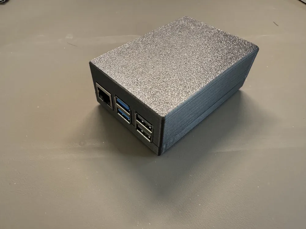 A finished black Raspberry Pi 5 case with the ports exposed.